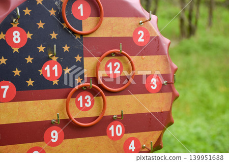 American Flag Bottle Cap Ring Toss Game Board Hanging on Tree Outdoors American Flag Bottle Cap Ring Toss Game Board Hanging on Tree Outdoors 139951688