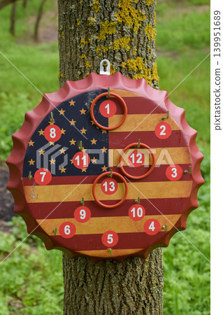 American Flag Bottle Cap Ring Toss Game Board Hanging on Tree Outdoors American Flag Bottle Cap Ring Toss Game Board Hanging on Tree Outdoors 139951689