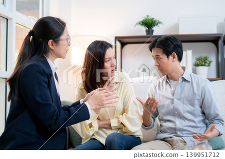 Asian couple arguing with therapist during home consultation. Asian couple arguing with therapist during home consultation. 139951712