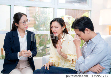 Asian couple arguing with therapist during home consultation. Asian couple arguing with therapist during home consultation. 139951717