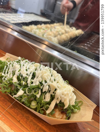 Enjoy takoyaki with plenty of green onion and mayonnaise right in front of the griddle. 139951799