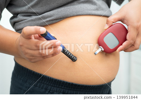 Asian woman injecting herself diabetes injecting insulin in stomach at home. Asian woman injecting herself diabetes injecting insulin in stomach at home. 139951844
