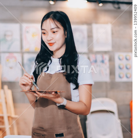 Female artist wears black hat posing near picture indoor the studio 139952409