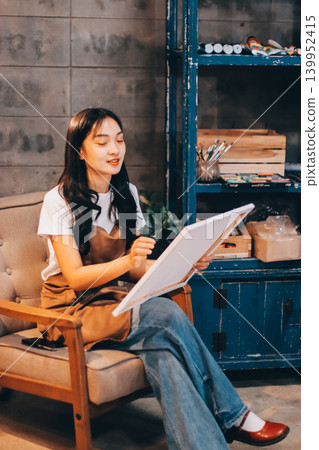 Female artist wears black hat posing near picture indoor the studio Female artist wears black hat posing near picture indoor the studio 139952415