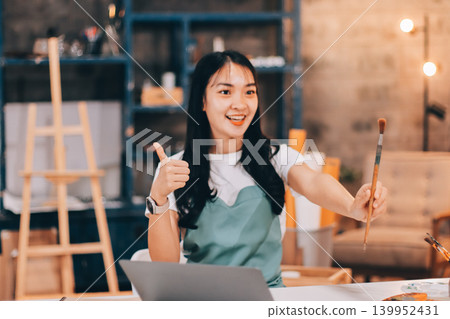 Female artist wears black hat posing near picture indoor the studio 139952431
