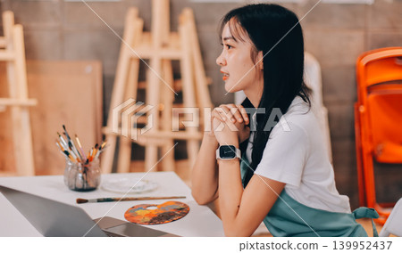 Female artist wears black hat posing near picture indoor the studio Female artist wears black hat posing near picture indoor the studio 139952437