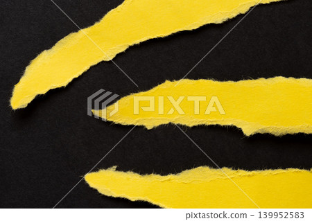 Torn yellow drawing paper on a black background Torn yellow drawing paper on a black background 139952583