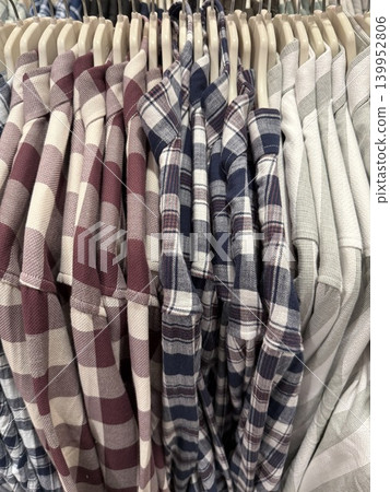 Stack of plaid shirts on hangers in retail store showcasing variety of colors and patterns Stack of plaid shirts on hangers in retail store showcasing variety of colors and patterns 139952806