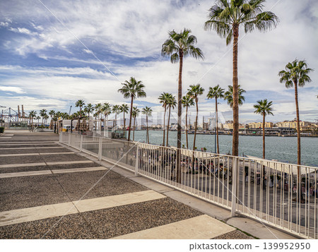 Palm-Lined Waterfront Promenade Overlooking Harbor and Malaga City Skyline With Marina and Walkway 139952950