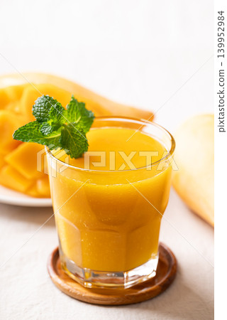 Fresh mango smoothie in a glass with ripe mango slices Fresh mango smoothie in a glass with ripe mango slices 139952984
