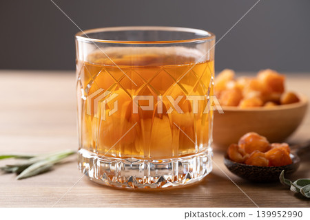 Longan juice in glass with dried longan fruit on wooden background Longan juice in glass with dried longan fruit on wooden background 139952990