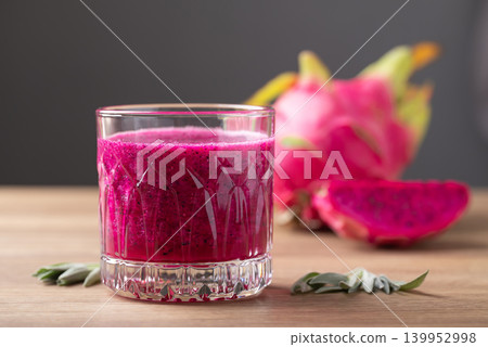 Glass of red dragon fruit smoothie on wooden background, Healthy tropical summer drink Glass of red dragon fruit smoothie on wooden background, Healthy tropical summer drink 139952998