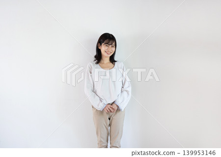 一位年輕的日本女子在白色背景前對著鏡頭微笑。 139953146