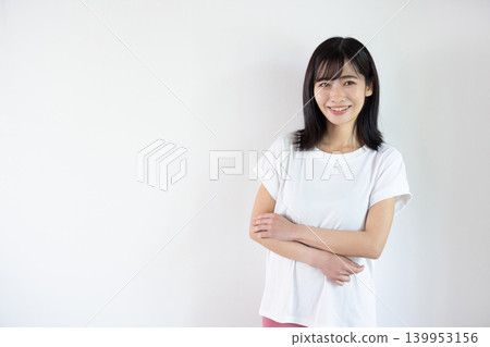一位年輕的日本女子在白色背景前對著鏡頭微笑。 139953156