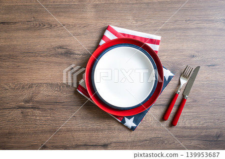 Patriotic table setting with empty white plate and american flag napkin on wooden background Patriotic table setting with empty white plate and american flag napkin on wooden background 139953687