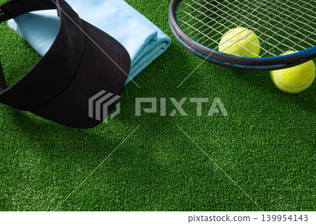 Tennis visor racket and towel on green grass with copy space Tennis visor racket and towel on green grass with copy space 139954143
