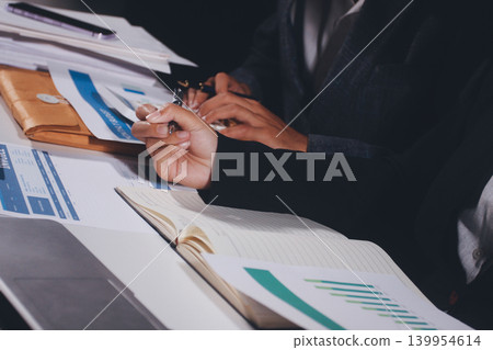 Professional photo of a person's hands reviewing a contract or legal document on a desk, for concepts of business, finance, and legal affairs Professional photo of a person's hands reviewing a contract or legal document on a desk, for concepts of business, finance, and legal affairs 139954614