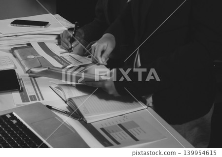 Professional photo of a person's hands reviewing a contract or legal document on a desk, for concepts of business, finance, and legal affairs Professional photo of a person's hands reviewing a contract or legal document on a desk, for concepts of business, finance, and legal affairs 139954615