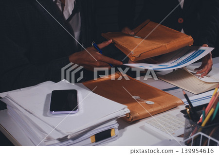 Professional photo of a person's hands reviewing a contract or legal document on a desk, for concepts of business, finance, and legal affairs Professional photo of a person's hands reviewing a contract or legal document on a desk, for concepts of business, finance, and legal affairs 139954616