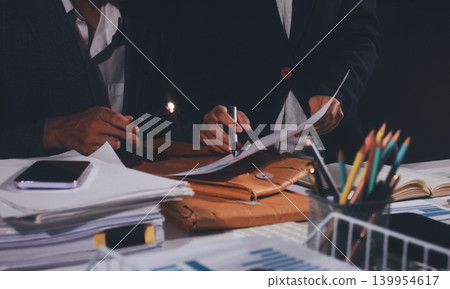 Professional photo of a person's hands reviewing a contract or legal document on a desk, for concepts of business, finance, and legal affairs Professional photo of a person's hands reviewing a contract or legal document on a desk, for concepts of business, finance, and legal affairs 139954617