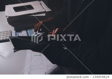 Professional photo of a person's hands reviewing a contract or legal document on a desk, for concepts of business, finance, and legal affairs Professional photo of a person's hands reviewing a contract or legal document on a desk, for concepts of business, finance, and legal affairs 139954624