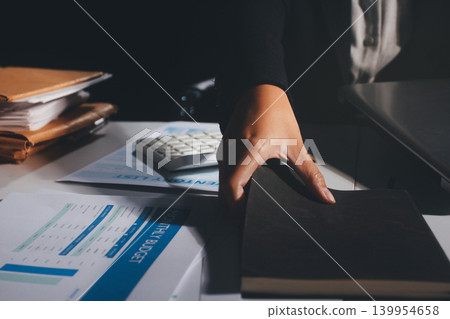 Professional photo of a person's hands reviewing a contract or legal document on a desk, for concepts of business, finance, and legal affairs Professional photo of a person's hands reviewing a contract or legal document on a desk, for concepts of business, finance, and legal affairs 139954658