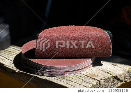 Stack of circular sanding discs for power tools on weathered wood surface Stack of circular sanding discs for power tools on weathered wood surface 139955126