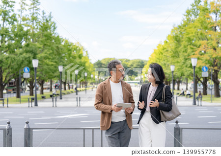 Two people talking while looking at a tablet Business Two people talking while looking at a tablet Business 139955778