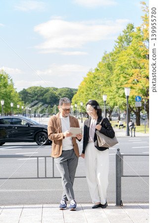 Two people talking while looking at a tablet Business 139955780