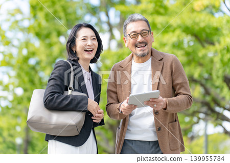 Two people talking while looking at a tablet Business Two people talking while looking at a tablet Business 139955784