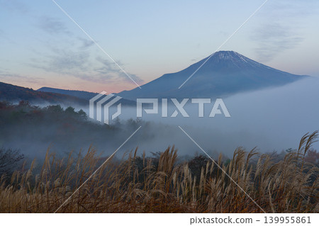 Mount Fuji shrouded in morning mist, as seen from a panoramic viewpoint near Lake Yamanaka. Mount Fuji shrouded in morning mist, as seen from a panoramic viewpoint near Lake Yamanaka. 139955861