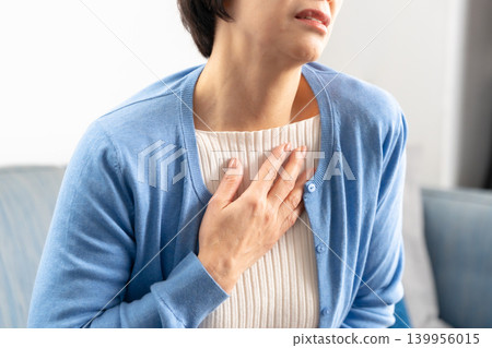 Senior woman experiencing palpitations and shortness of breath Senior woman experiencing palpitations and shortness of breath 139956015