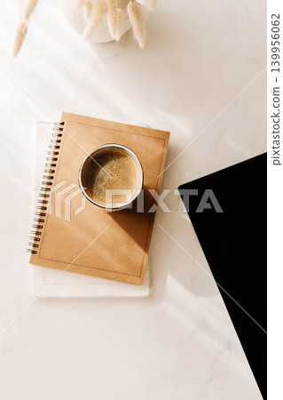 Minimal desk flat lay with coffee cup, notebook and laptop corner on a white background Minimal desk flat lay with coffee cup, notebook and laptop corner on a white background 139956062