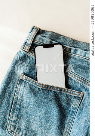 Smartphone with blank screen in a blue denim jeans pocket Smartphone with blank screen in a blue denim jeans pocket 139956063