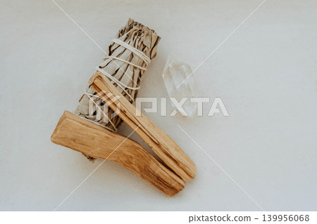 White sage bundle, palo santo stick and clear quartz crystal on light background 139956068