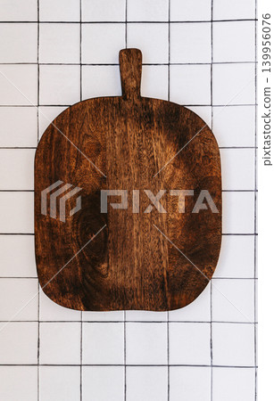 Wooden cutting board on tiled background Wooden cutting board on tiled background 139956076