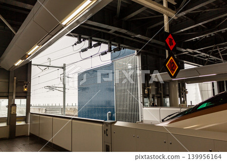 Trains stopping at Shinkansen station platforms during snowfall and stopping position markers [Hokuriku Shinkansen, Tsuruga Station] 139956164