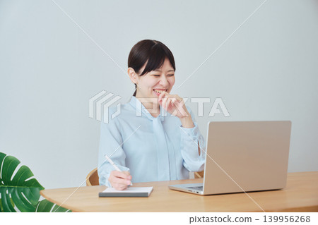 A woman smiling while working from home. A woman smiling while working from home. 139956268