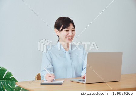 一位在家工作的女性面帶微笑。 139956269