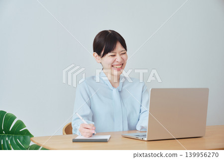 A woman smiling while working from home. 139956270
