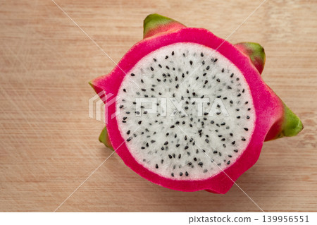 Freshly cut dragon fruit. Slices of delicious pitahaya fruit on wooden background Freshly cut dragon fruit. Slices of delicious pitahaya fruit on wooden background 139956551