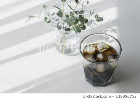 A simple table scene with summer sunshine and iced coffee. A simple table scene with summer sunshine and iced coffee. 139956752