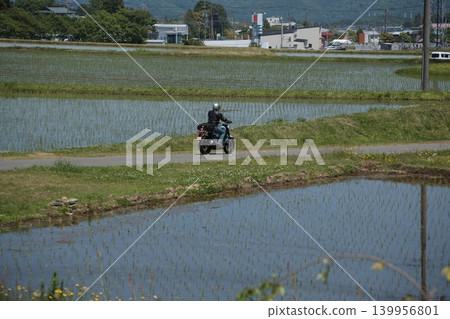 一輛摩托車行駛在鄉村道路上的場景。 139956801