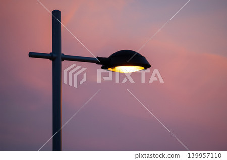 Street Lamp Lit at Sunset in Urban Setting Street Lamp Lit at Sunset in Urban Setting 139957110