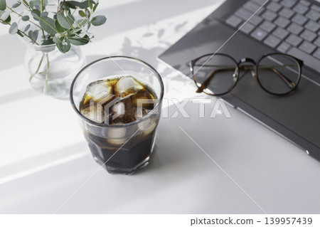 A summer workspace with iced coffee and a laptop. 139957439