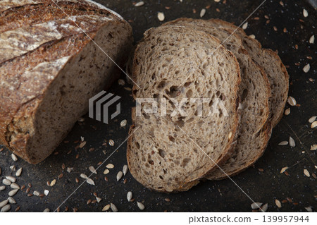 Sliced Sunflower Seed Bread Presentation. Artisan Sunflower Seed Bread on Rustic Surface. Sliced Sunflower Seed Bread Presentation. Artisan Sunflower Seed Bread on Rustic Surface. 139957944