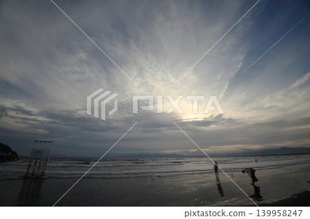 夕陽西下,湘南海岸上空,一位女子在海浪中嬉戲的剪影。 夕陽西下,湘南海岸上空,一位女子在海浪中嬉戲的剪影。 139958247