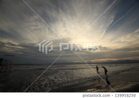 黃昏時分，與漂浮在海面上的雲朵和波浪嬉戲。 139958250