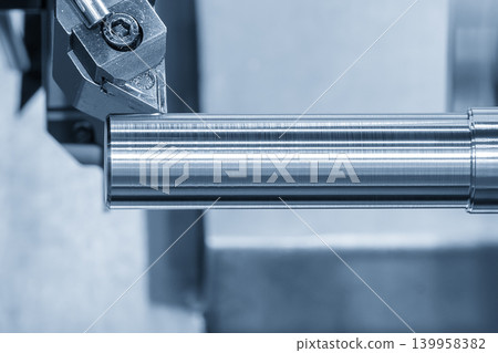 Close-up of an indexable carbide insert on a CNC lathe turning machine during a precision finishing cut on a metal shaft part. Close-up of an indexable carbide insert on a CNC lathe turning machine during a precision finishing cut on a metal shaft part. 139958382