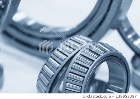 Close-up of a high-precision taper rolling bearing component in a light blue-toned industrial scene. Close-up of a high-precision taper rolling bearing component in a light blue-toned industrial scene. 139958387